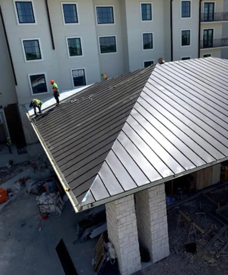 Crew installing standing seam metal roof panels on a commercial project in Chambersburg